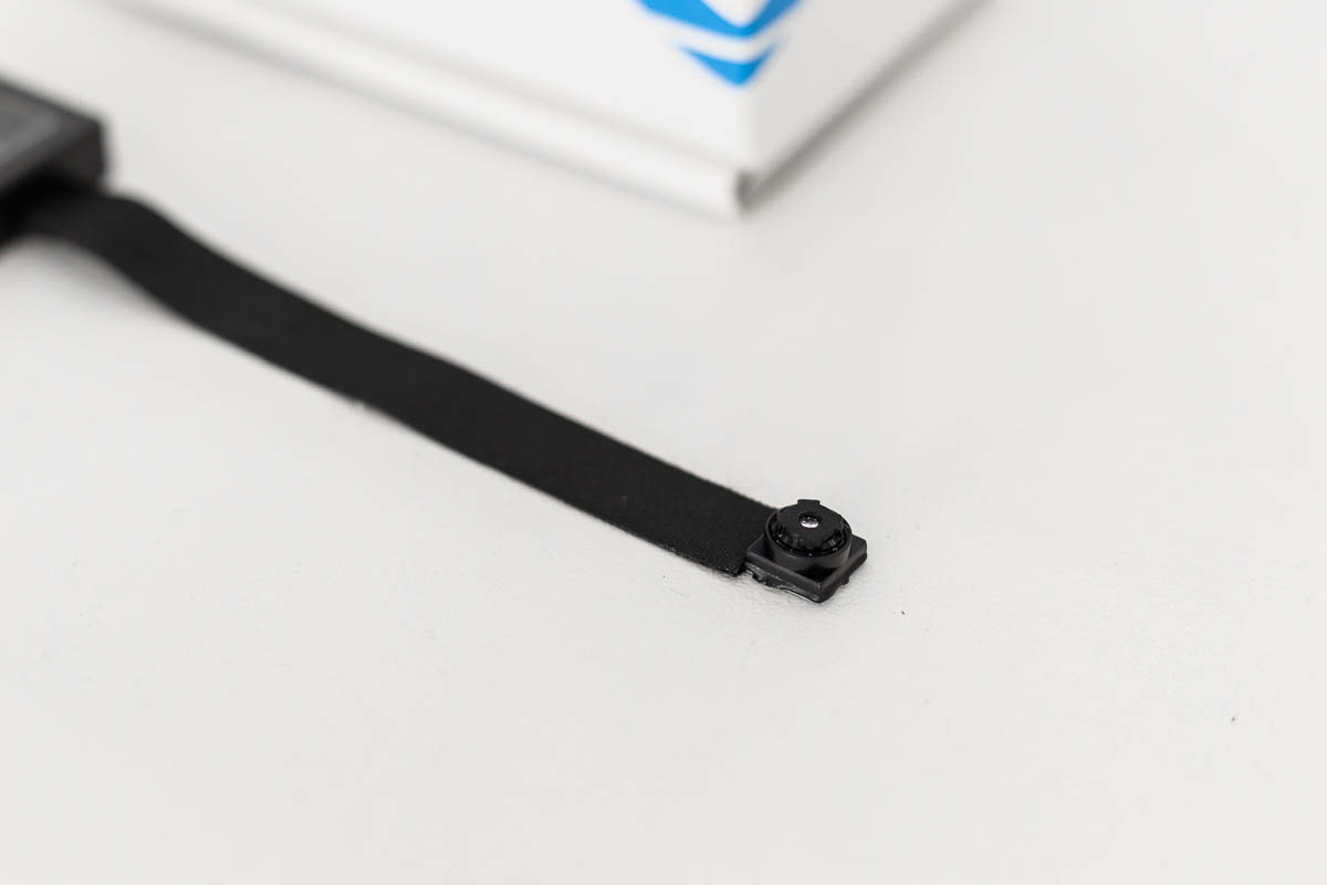 Primo piano dell’ottica della microcamera con DVR full HD e rilevamento movimento, cavo flat nero flessibile – CAM.04