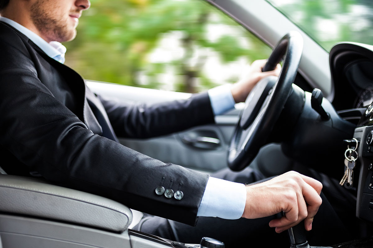 Un uomo alla guida della sua auto. Se temi di essere spiato, leggi la guida "Come capire se hai un localizzatore GPS in auto"