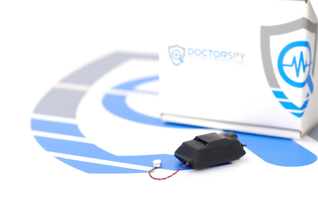 Una microspia audio Doctorspy con microfono esterno e scatola sullo sfondo