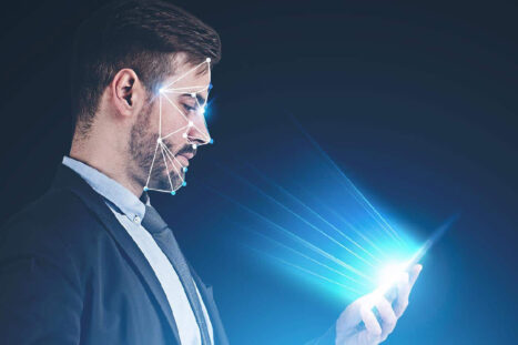 Un individuo guarda un cellulare con riconoscimento facciale