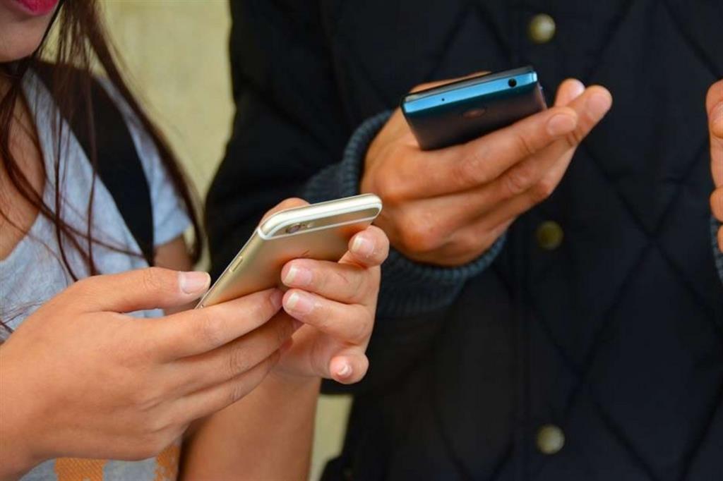Due persone controllano i propri cellulari